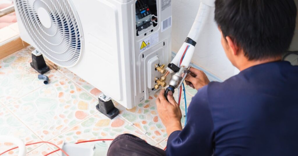 Un spécialiste raccorde les unités intérieure et extérieure d'un système de climatisation. 